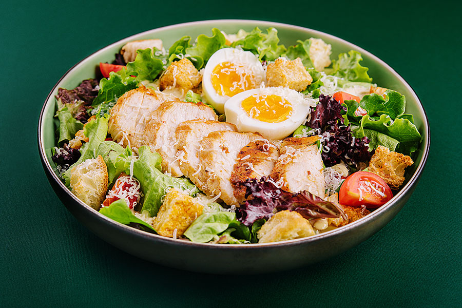 A tradicional salada Caesar é leve e combina perfeitamente com a crocância de um delicioso frango empanado. Aprenda como preparar essa receitinha.